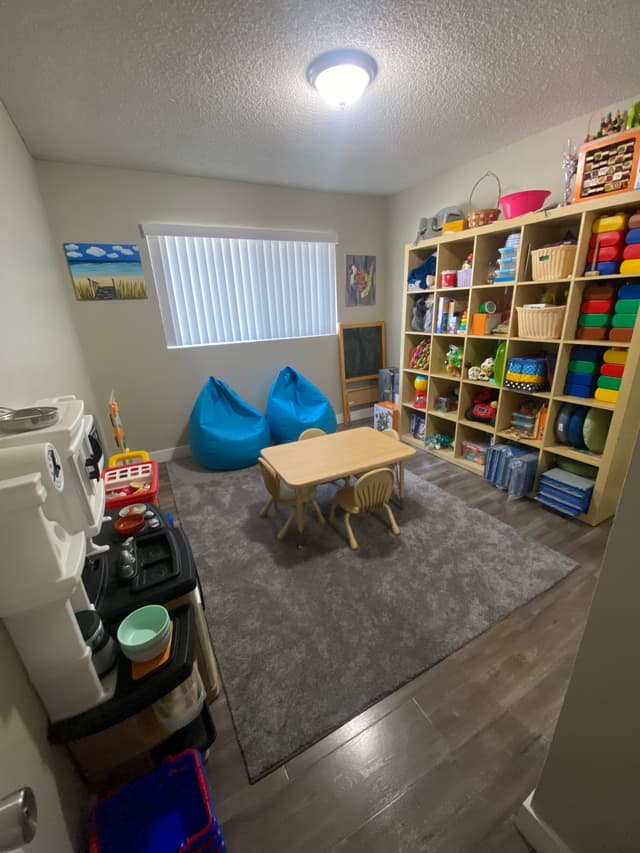 picture of a playroom in a daycare with toys, chairs, and games little kids can play